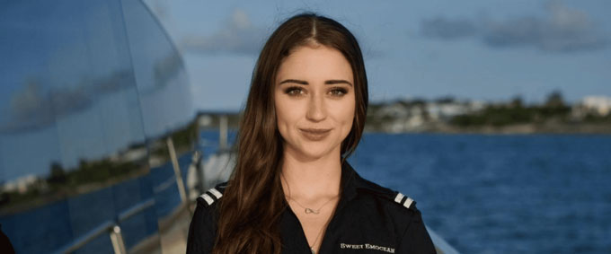 Young female crew member standing on a superyacht deck