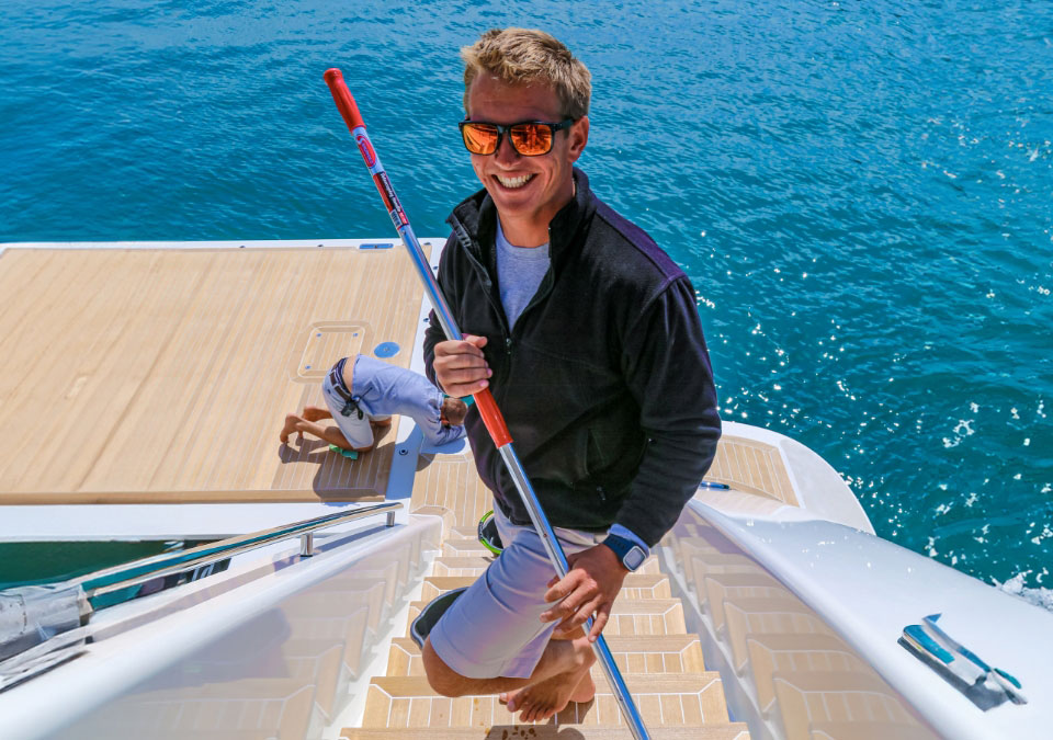 Deck crew chamois mopping aft deck on a superyacht
