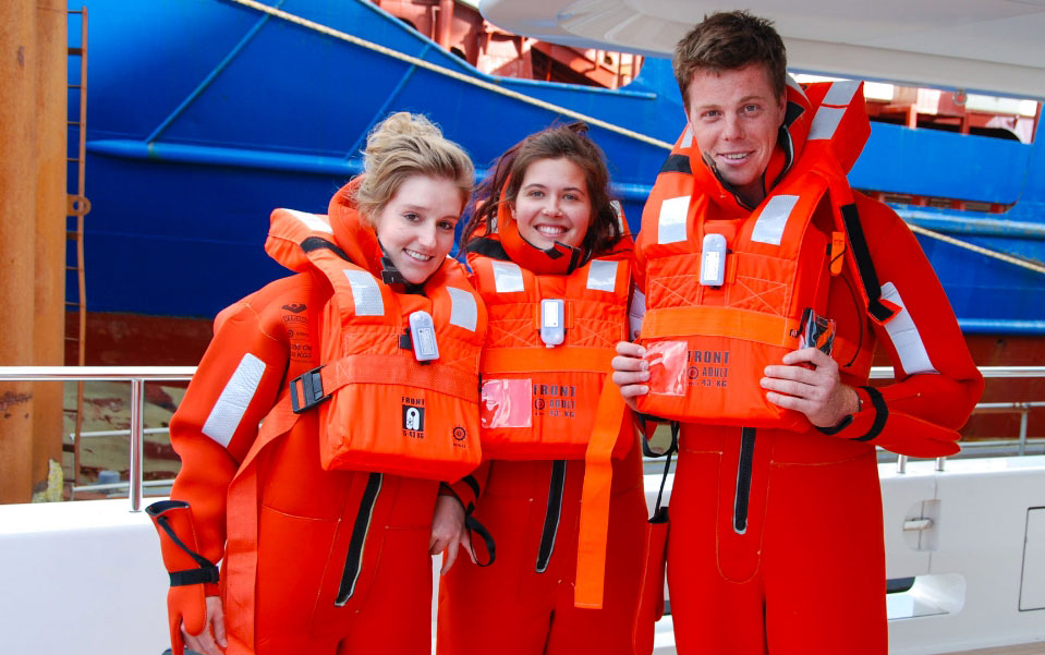 Yacht crew completing safety training in immersion suits and life jackets