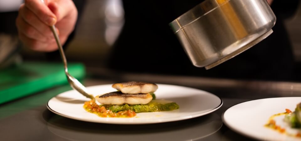 Head Chef plating a fine dining dish on a superyacht