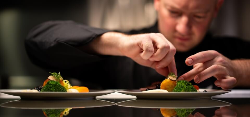Chef carefully plating a dish with precision