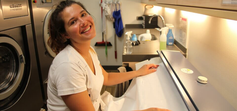 Crew member managing laundry on a luxury yacht