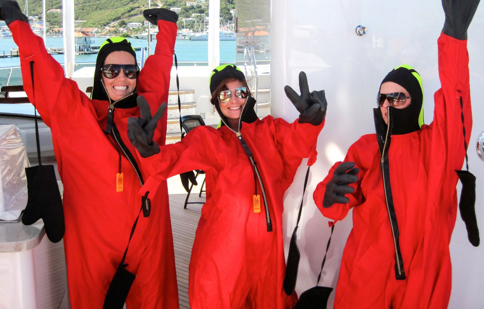 Yacht stewardesses completing safety training in immersion suits