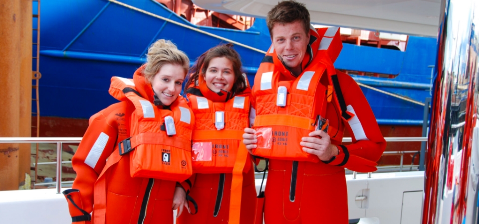 Crew of a superyacht completing safety training in immersion suits and life jackets