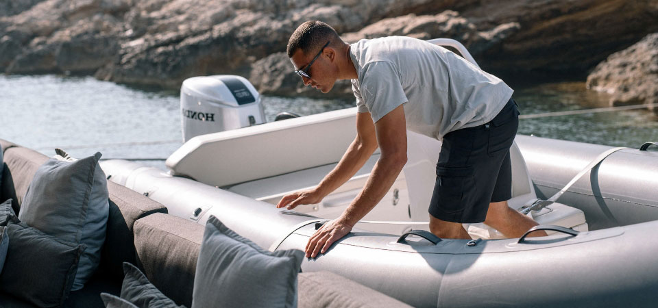 Deck crew member deploying a tender on a yacht, preparing to collect guests
