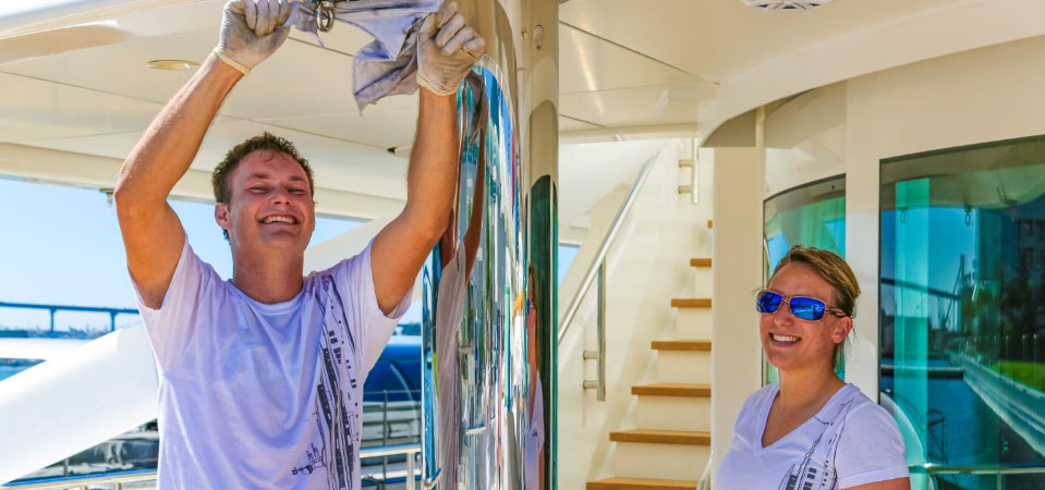 Deckhand and stewardess collaboratively polishing stainless steel on a superyacht